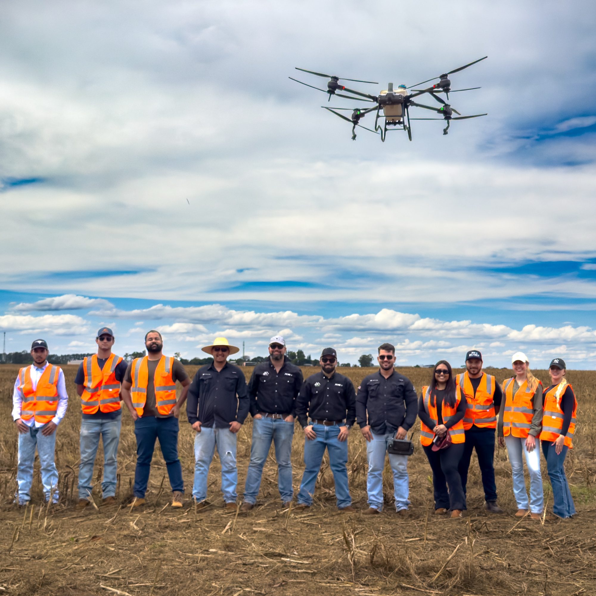 Turma do CPAR em campo, com um drone agrícola voando acima do grupo